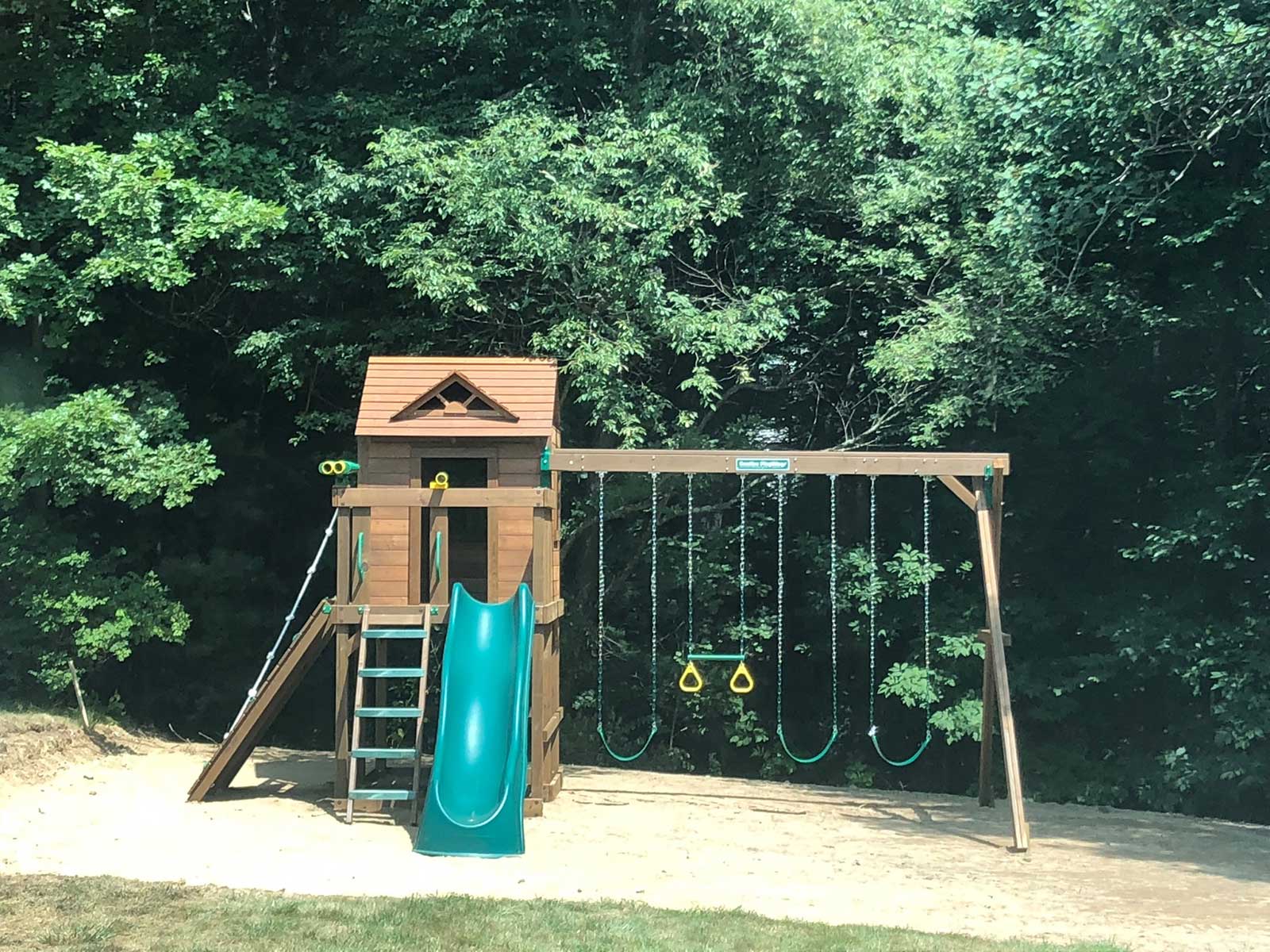 Customer image of a residential Creative Playthings swing set in a yard.